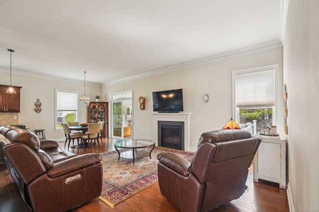 living room featuring baseboards, dark wood finished floors, a glass covered fireplace, and crown molding
