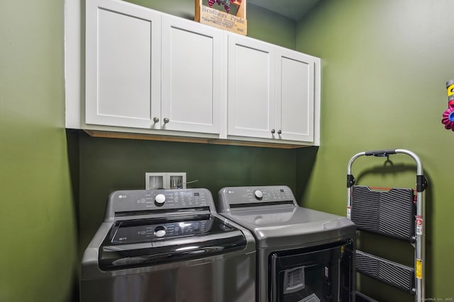 washroom featuring separate washer and dryer and cabinet space