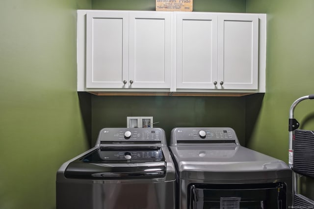 laundry room featuring washing machine and dryer and cabinet space