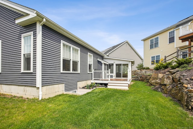 rear view of house with a deck and a lawn