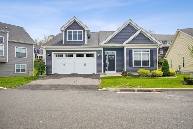 craftsman-style home featuring a garage, driveway, and a front yard
