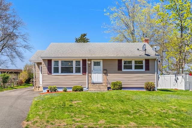 view of front of property with a front yard, fence, a chimney, and entry steps