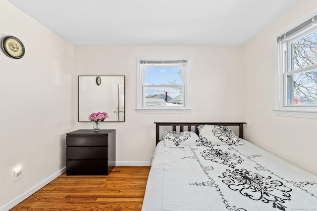 bedroom featuring baseboards and wood finished floors