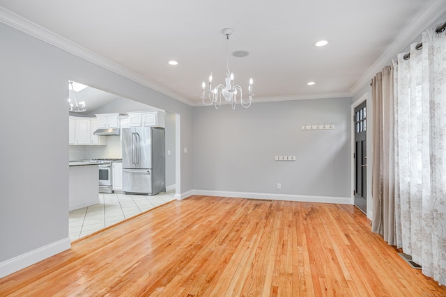 unfurnished living room featuring an inviting chandelier, ornamental molding, and light wood-type flooring
