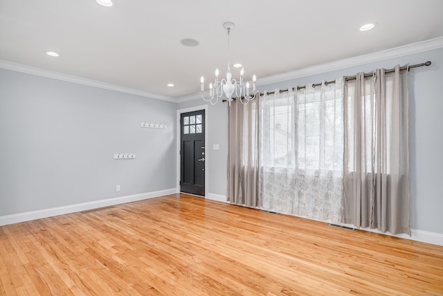 spare room with crown molding, wood finished floors, baseboards, recessed lighting, and a chandelier