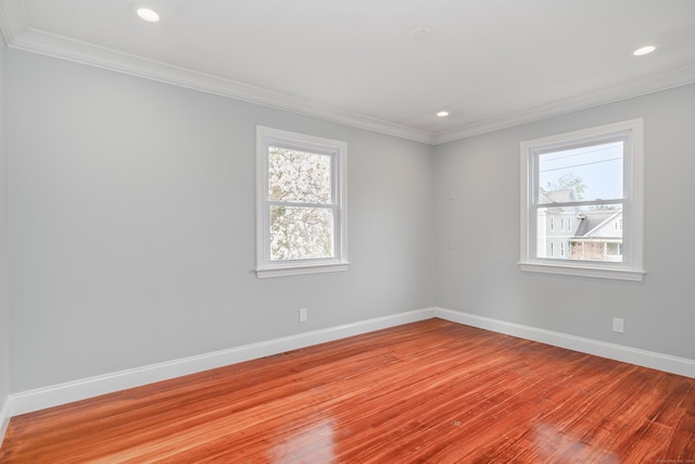 spare room with crown molding, baseboards, recessed lighting, and light wood finished floors