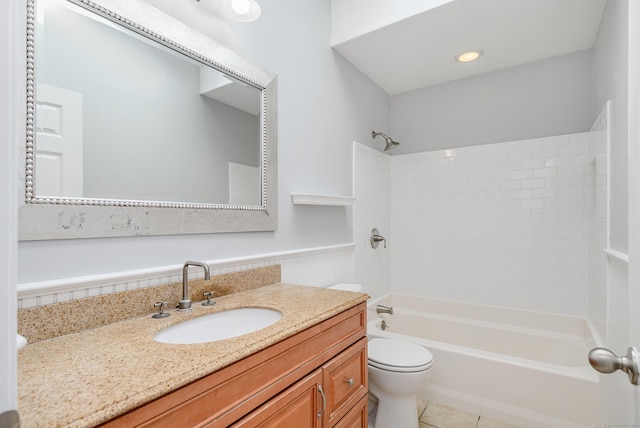 full bath featuring tile patterned flooring, wainscoting, vanity, toilet, and bathing tub / shower combination