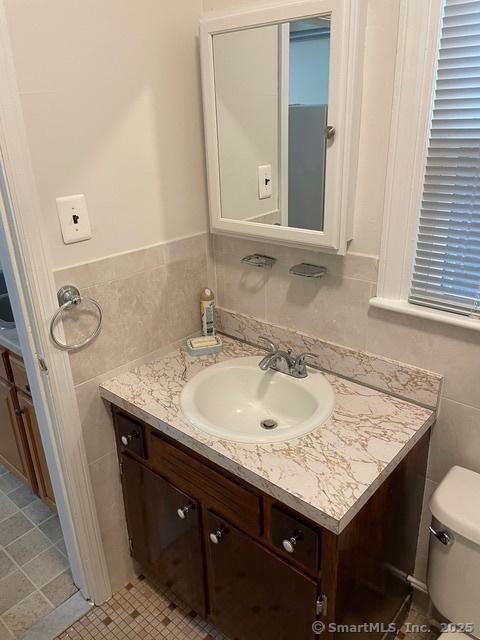 302 High St, Naugatuck, CT 06770 - half bathroom featuring tile walls, vanity, and toilet
