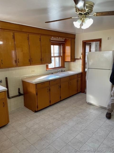 302 High St, Naugatuck, CT 06770 - kitchen featuring light countertops, a sink, freestanding refrigerator, brown cabinetry, and ceiling fan