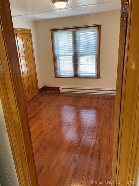 302 High St, Naugatuck, CT 06770 - empty room with baseboards, hardwood / wood-style floors, and baseboard heating