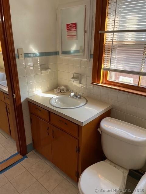 302 High St, Naugatuck, CT 06770 - bathroom with toilet, vanity, tile patterned floors, and tile walls