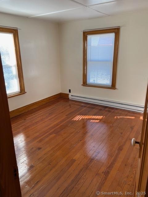 302 High St, Naugatuck, CT 06770 - spare room with a baseboard radiator, wood-type flooring, and baseboards