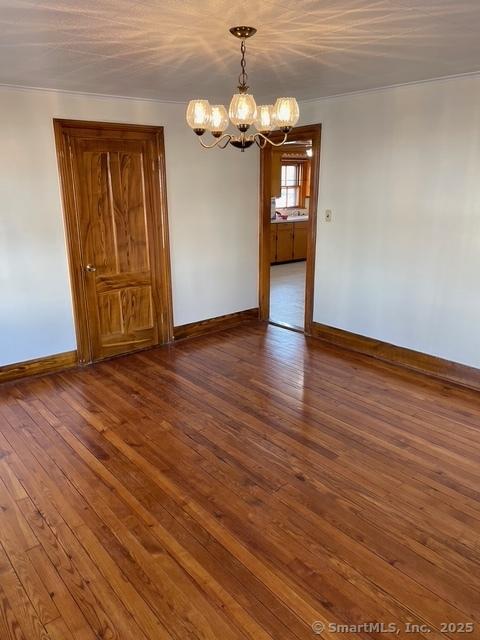 302 High St, Naugatuck, CT 06770 - empty room with hardwood / wood-style floors, baseboards, a chandelier, and crown molding