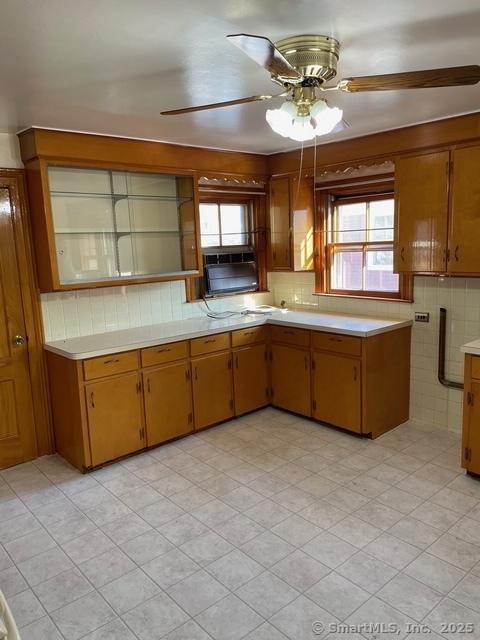 302 High St, Naugatuck, CT 06770 - kitchen with plenty of natural light, ceiling fan, brown cabinetry, and light countertops