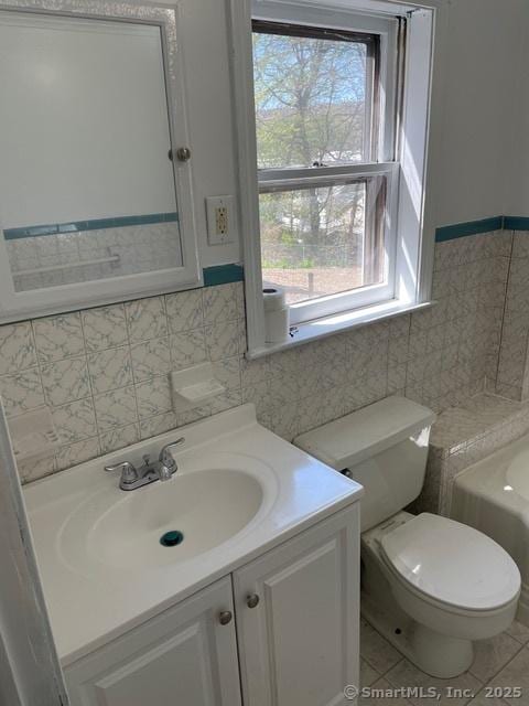 302 High St, Naugatuck, CT 06770 - bathroom with a bathtub, toilet, tile walls, tile patterned flooring, and vanity