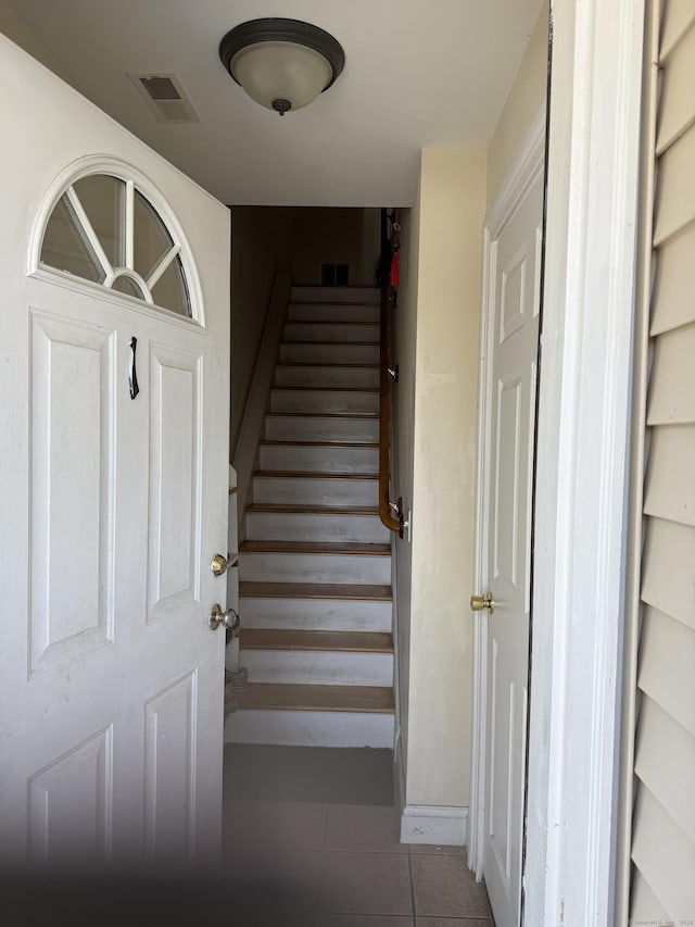 staircase featuring tile patterned flooring and visible vents