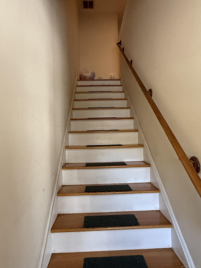 staircase with wood finished floors and visible vents