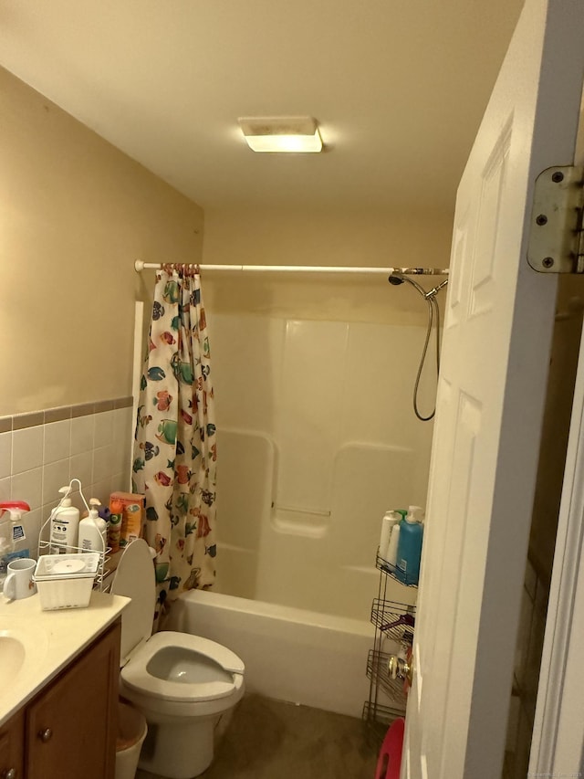 bathroom featuring toilet, tile walls, wainscoting, shower / bathtub combination with curtain, and vanity