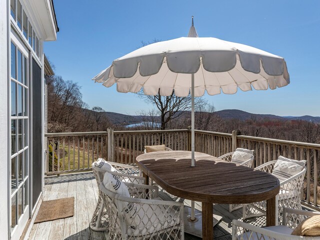 293 Lake Rd, Warren, CT 06777 - deck with outdoor dining area, a mountain view, and a wooded view