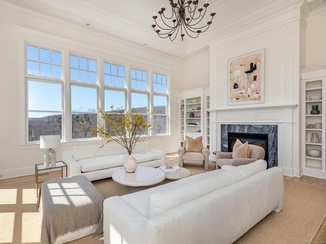 293 Lake Rd, Warren, CT 06777 - living room with a chandelier, baseboards, a premium fireplace, crown molding, and light wood finished floors