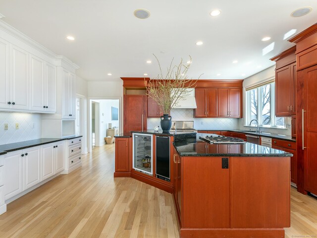 293 Lake Rd, Warren, CT 06777 - kitchen featuring wine cooler, a kitchen island, backsplash, light wood finished floors, and stainless steel appliances