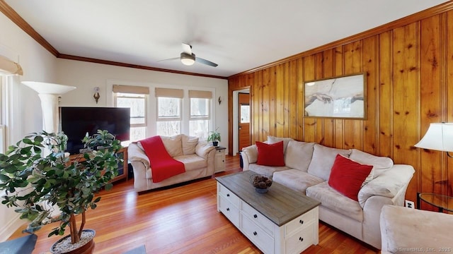 335 Paradise Ave, Hamden, CT 06514 - living area with wooden walls, light wood-style flooring, crown molding, and ceiling fan