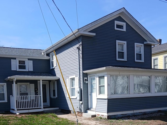 traditional-style home featuring a porch and a sunroom