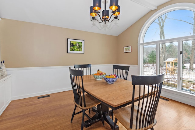 dining area featuring visible vents, wood finished floors, a wealth of natural light, and a chandelier