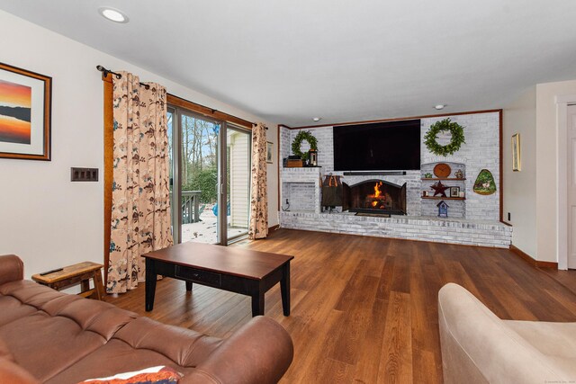 living area featuring a fireplace, wood finished floors, baseboards, and recessed lighting