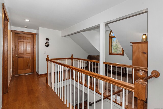 corridor featuring an upstairs landing, baseboards, wood finished floors, and recessed lighting