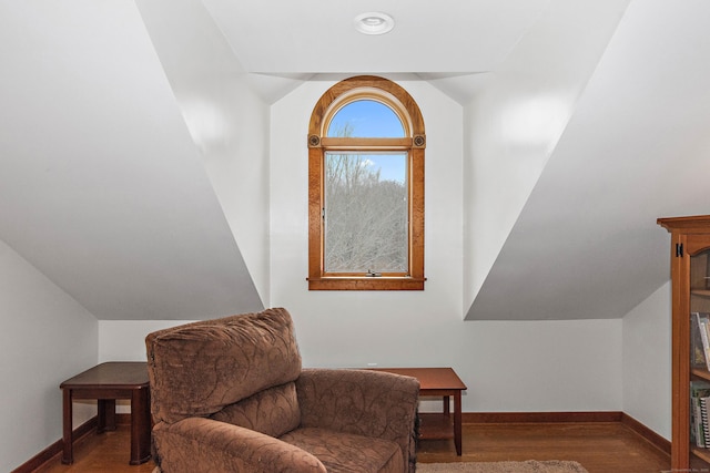 sitting room with lofted ceiling, baseboards, and wood finished floors
