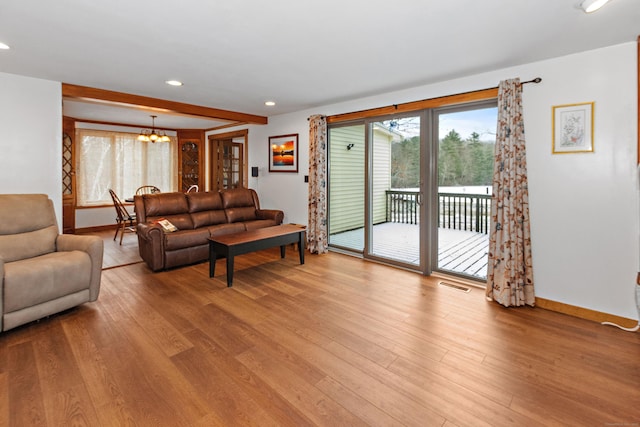 living area featuring wood finished floors, baseboards, a notable chandelier, visible vents, and recessed lighting