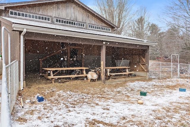 snow covered property with an outbuilding