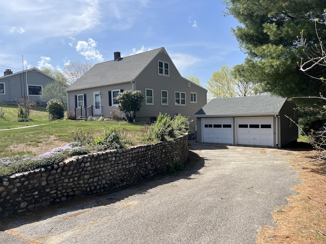 view of front of home with an outdoor structure, a shingled roof, and a garage