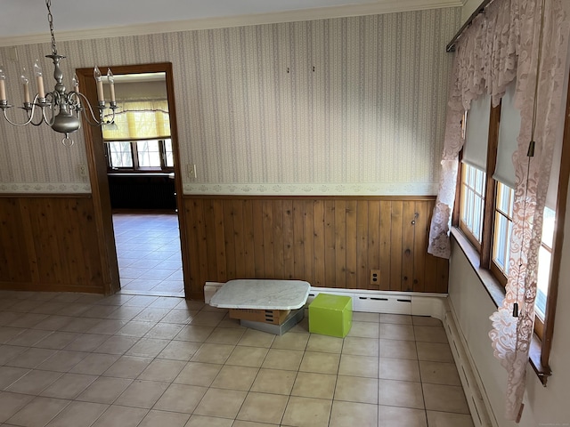spare room with a wainscoted wall, a chandelier, and wallpapered walls
