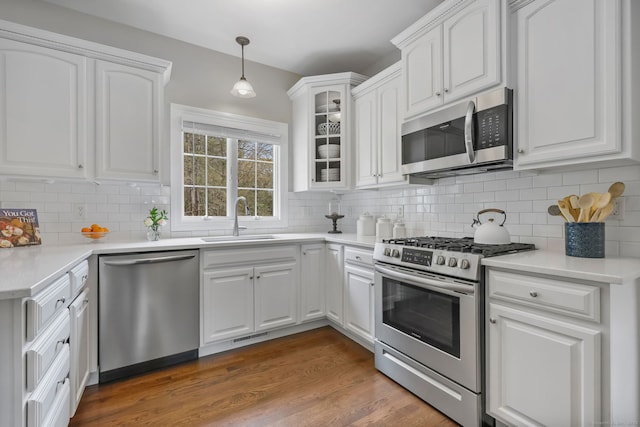 12 Canoe Brook Rd, Trumbull, CT 06611 - kitchen with wood finished floors, decorative backsplash, stainless steel appliances, a sink, and white cabinetry