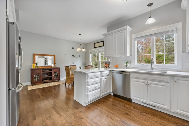 12 Canoe Brook Rd, Trumbull, CT 06611 - kitchen with a sink, tasteful backsplash, a peninsula, white cabinetry, and appliances with stainless steel finishes