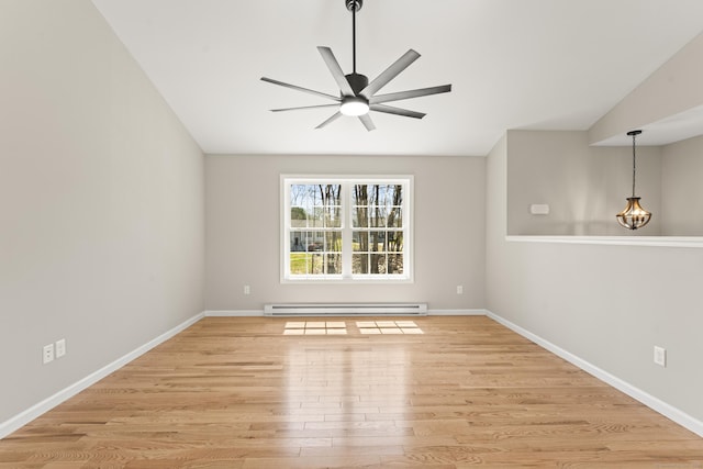 spare room featuring a baseboard radiator, light wood-type flooring, baseboards, and ceiling fan