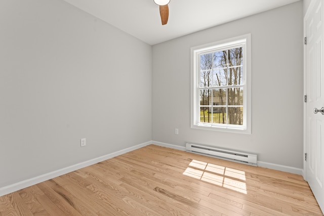 empty room with baseboard heating, ceiling fan, a wealth of natural light, and light wood finished floors