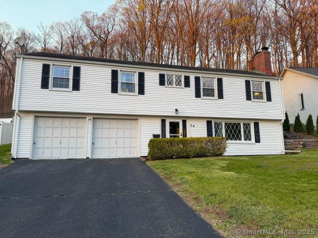 74 Forest Dr, Newington, CT 06111 - colonial inspired home with a garage, a chimney, a front lawn, and aphalt driveway