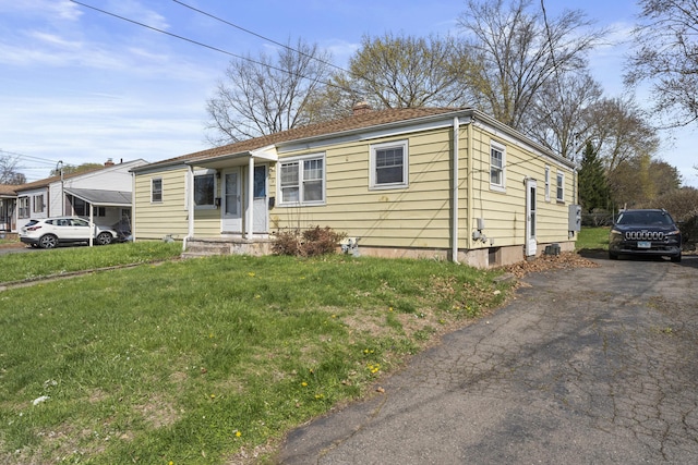view of front facade featuring a chimney and a front yard