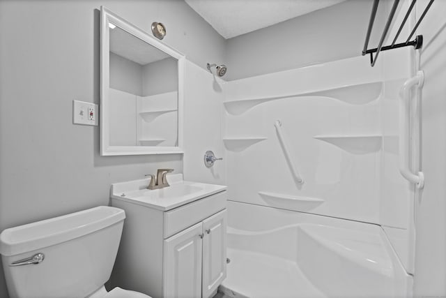 bathroom featuring walk in shower, toilet, and vanity