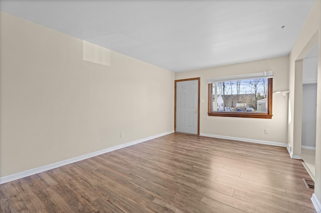 unfurnished bedroom with visible vents, baseboards, and wood finished floors