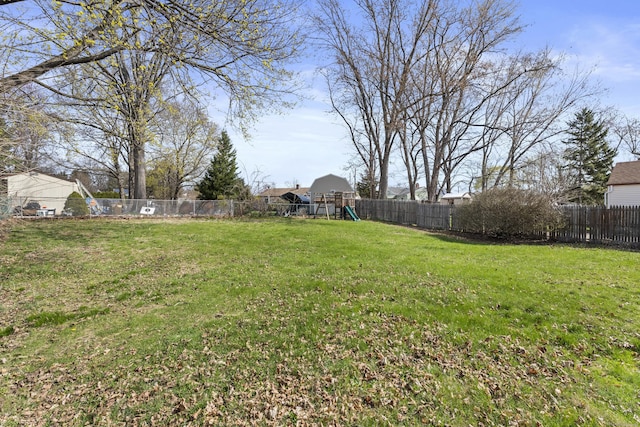 view of yard with a fenced backyard and a playground