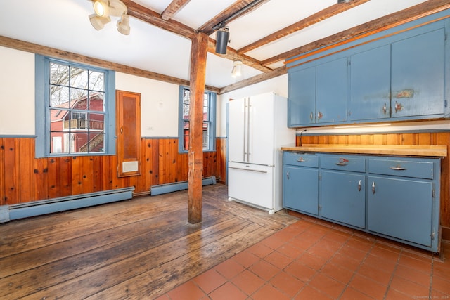 1156 Exeter Rd, Lebanon, CT 06249 - kitchen featuring a wainscoted wall, baseboard heating, wood walls, blue cabinetry, and dark tile patterned flooring