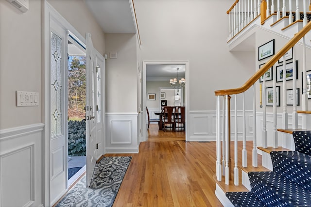 10 Granite Rd, New Milford, CT 06776 - foyer entrance with a wainscoted wall, light wood-style floors, a decorative wall, stairs, and a notable chandelier