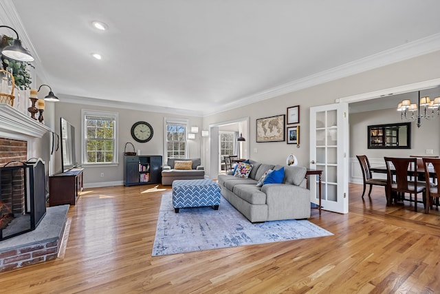 10 Granite Rd, New Milford, CT 06776 - living area with light wood finished floors, a brick fireplace, a notable chandelier, and crown molding