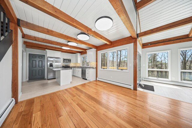 kitchen with white cabinets, a baseboard radiator, stainless steel appliances, a baseboard heating unit, and beam ceiling