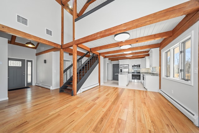 unfurnished living room featuring visible vents, a baseboard heating unit, beamed ceiling, and baseboard heating