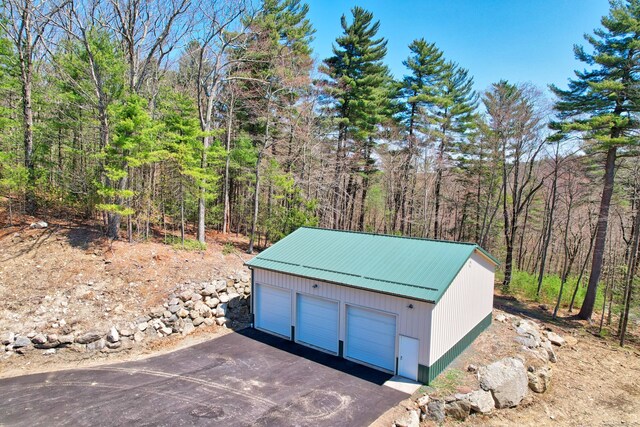 view of outdoor structure featuring an outbuilding and a forest view